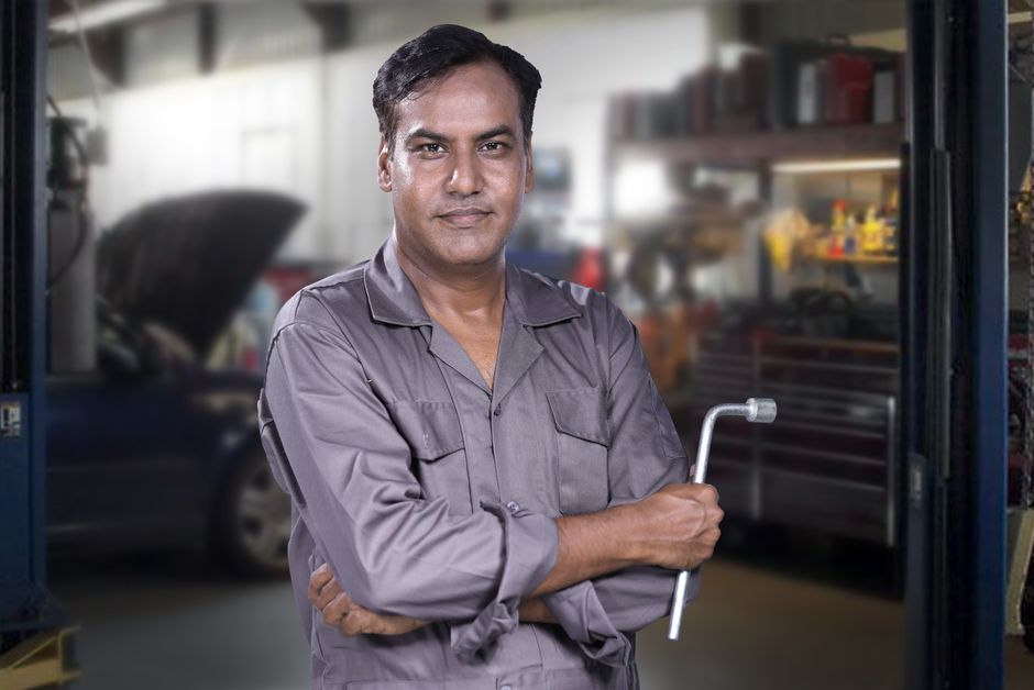 Smiling auto mechanic ready for tire installation